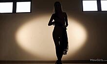 O femeie flexibilă cu părul lung dansează în lenjerie erotică seducătoare