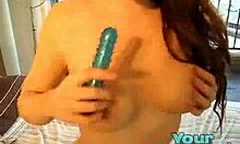 Wanita berambut coklat yang berisi memasukkan dildo biru ke dalam vaginanya